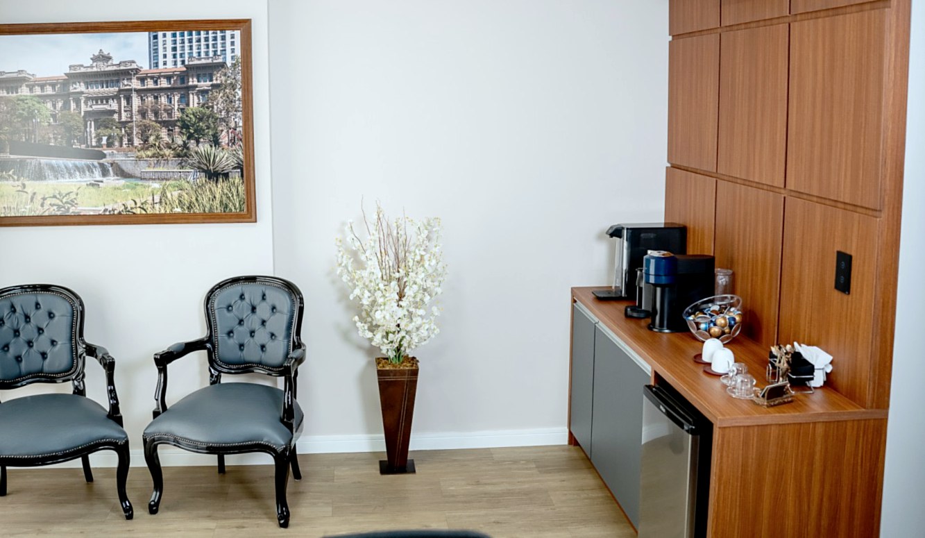 Sala de espera com duas poltronas e bancada de café