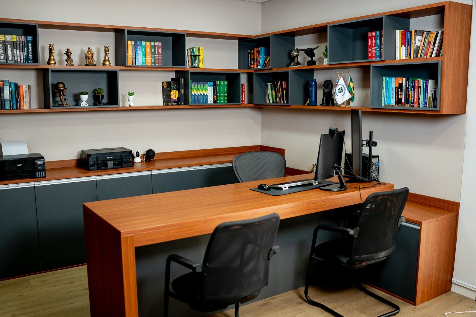 Sala do advogado com estantes de livros jurídicos e mesa de atendimento